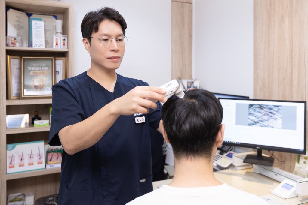 윤종진 대표원장이 직접 두피 진단 장비로 환자를 진료하는 모습